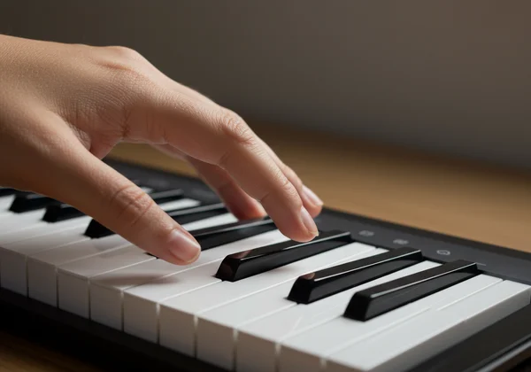 Rechte Hand spielt Noten auf einer virtuellen Klaviertastatur.
